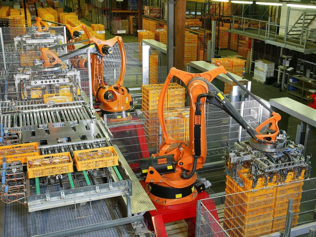 Humanoid Robots Begin Carefully Supervised Factory Pilots An industrial robot on a factory line